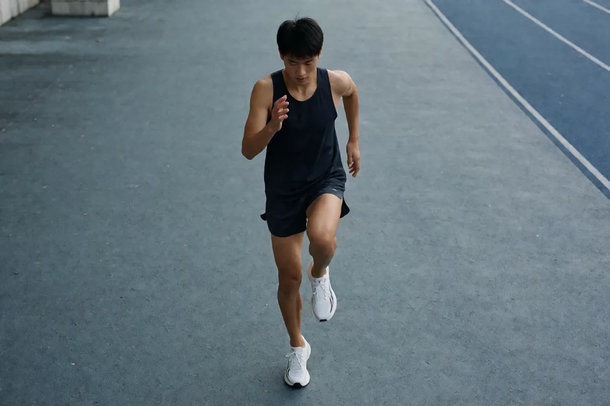 马拉松起跑前跑者在赛道边做动态拉伸与激活动作